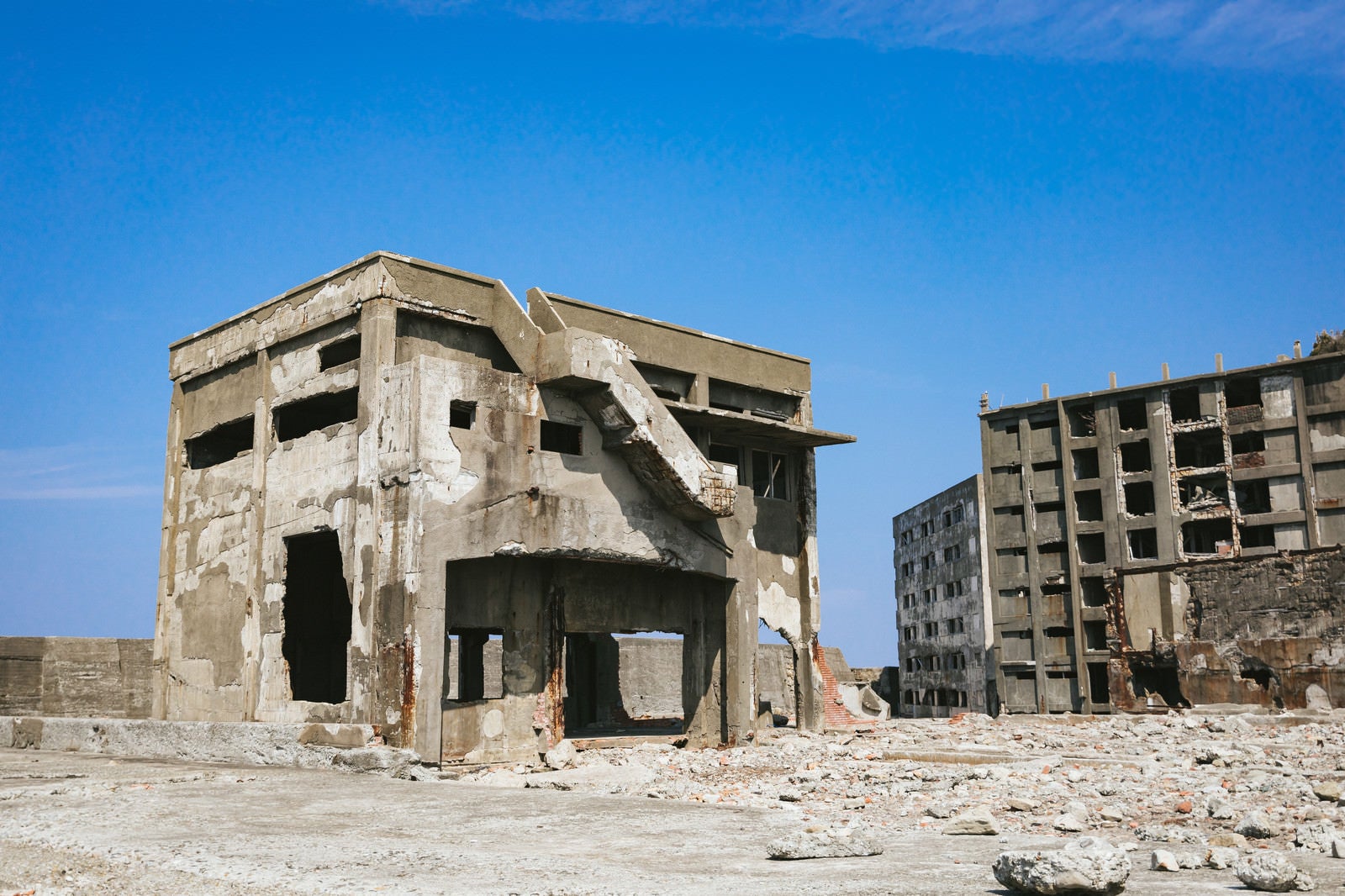 「軍艦島の崩れ行く鉄筋の建物と瓦礫」の写真