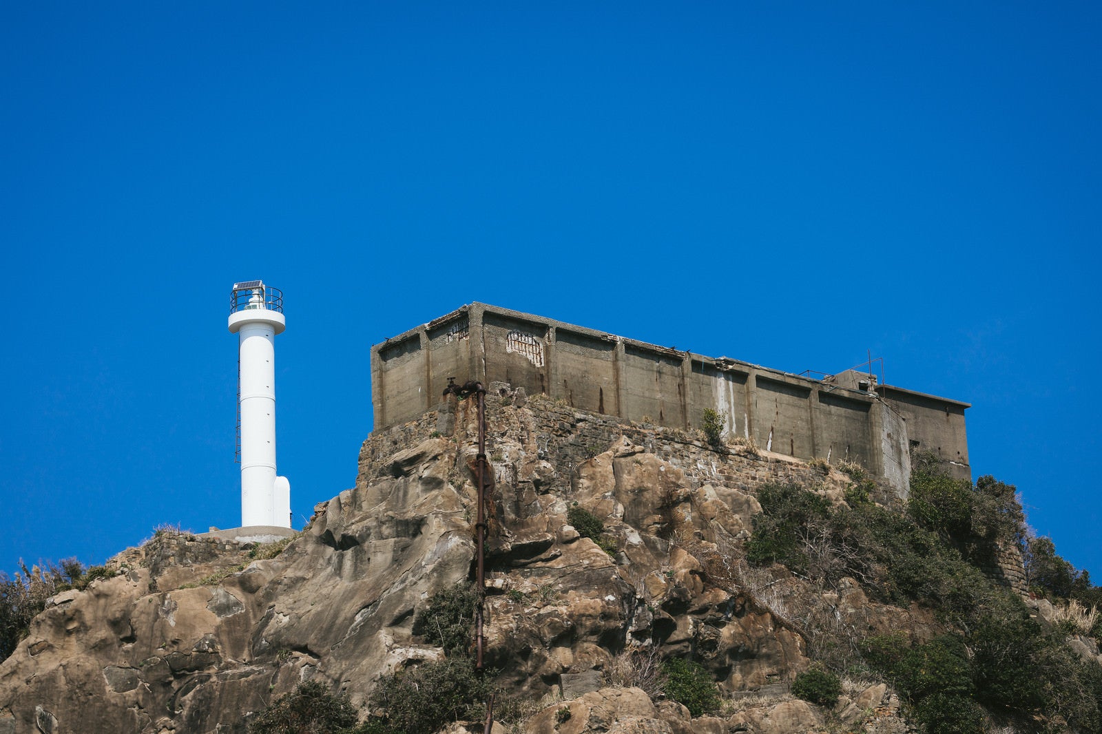 「肥前端島灯台の隣にある巨大な貯水槽（軍艦島）」の写真