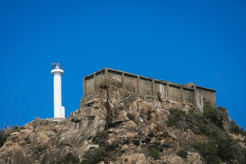 肥前端島灯台の隣にある巨大な貯水槽（軍艦島）の写真