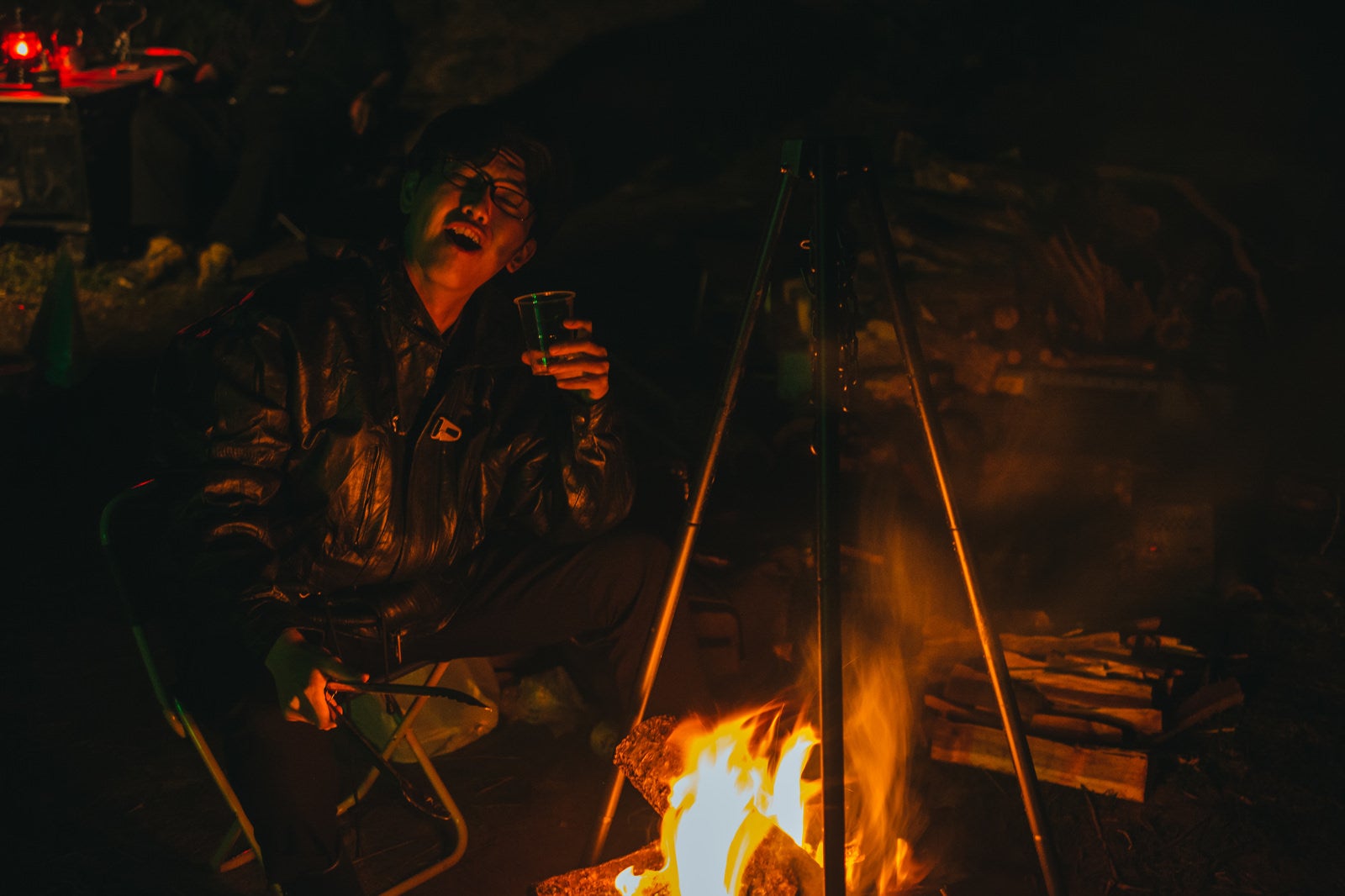 「深夜のキャンプ上で飲んだくれる男性」の写真［モデル：花和瞭］