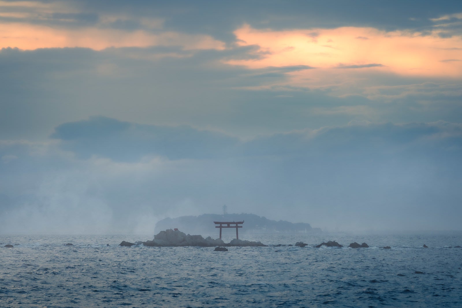 「夕暮れの海に浮かぶ鳥居」の写真