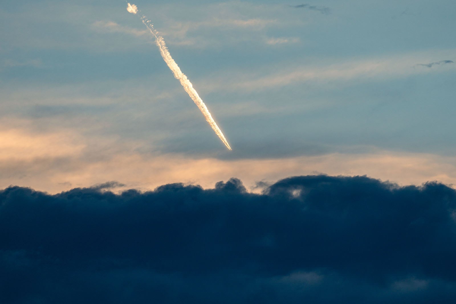 「灰色雲と飛行機雲」の写真