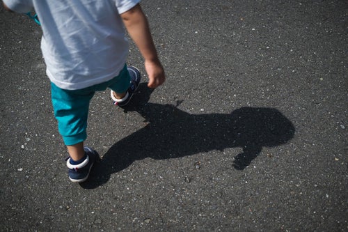 散歩する子供と影の写真