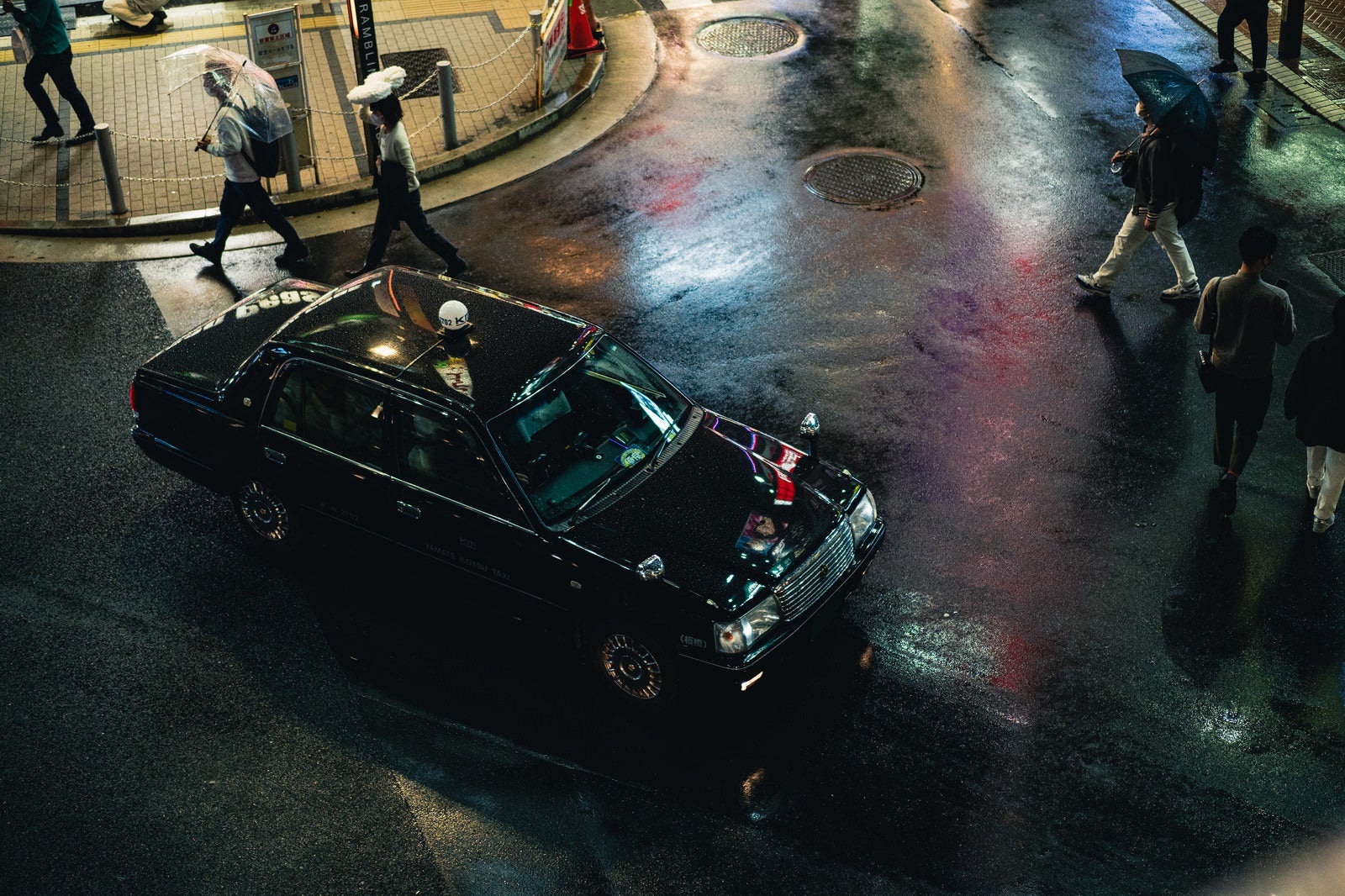 「雨が降る繁華街とタクシー」の写真