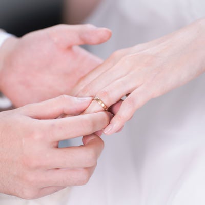 結婚指輪を左手薬指にはめる様子の写真