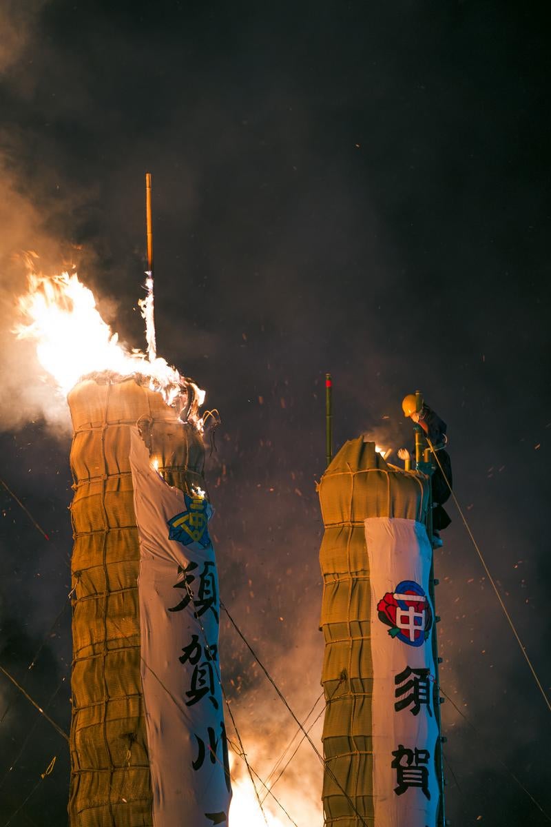 「会場に飛び散る火花と大松明に点火する雄姿」の写真