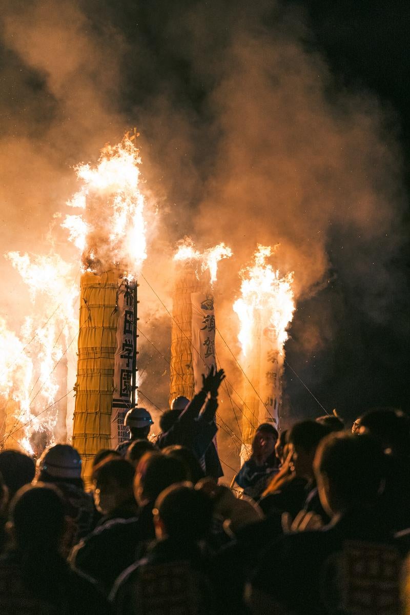 「燃え上がる炎と立ち上がる煙の松明あかしの巨大松明」の写真