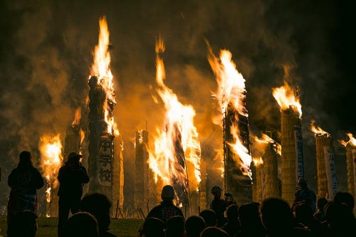 観客の前で燃え上がる巨大な松明の火柱の写真