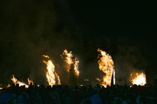 松明あかしの大松明の炎と風に舞う火花の写真
