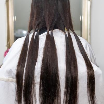 ヘアドネーションのために髪を束ねて分けるの写真