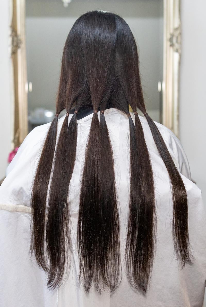 ヘアドネーションのために髪を束ねて分けるの写真