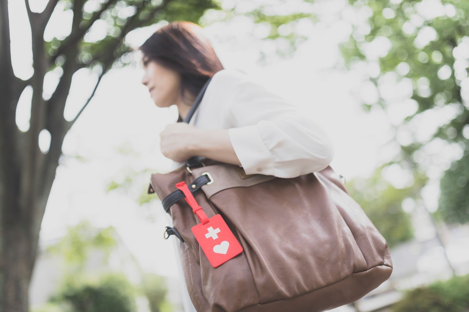 「ヘルプマークをバッグにつけて出社する女性」の写真［モデル：土本寛子］
