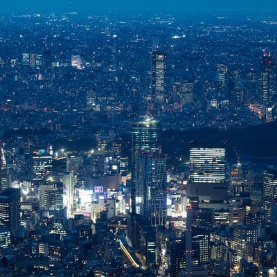 渋谷付近のビル群と空撮夜景の写真