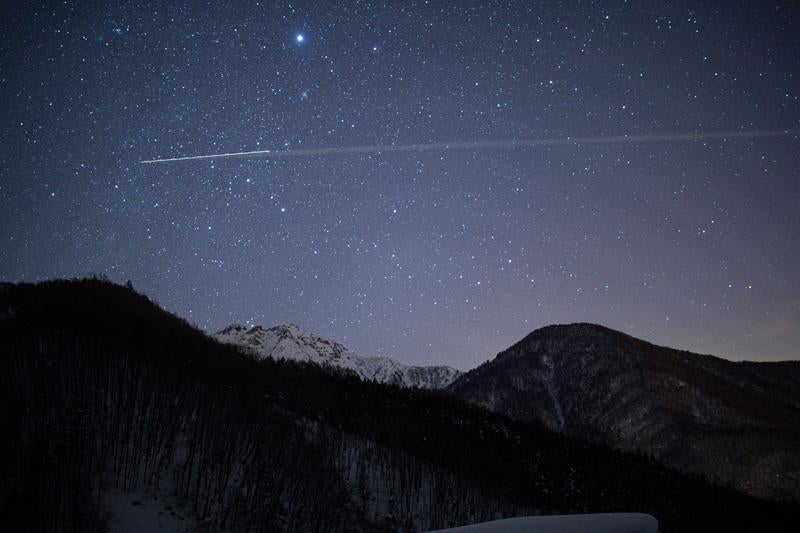 冬の山岳地帯に煌めく星座の輝きの写真