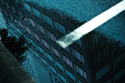 水たまりに反射するビルの写真