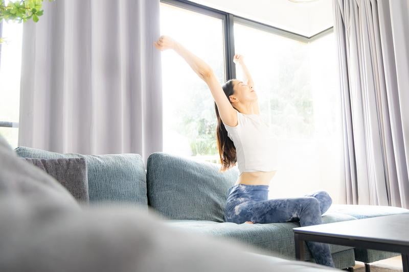 ソファで伸びをする女性の写真