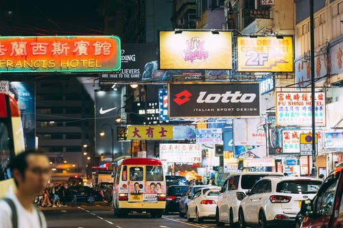 夜の香港のネオン看板と渋滞する車の写真
