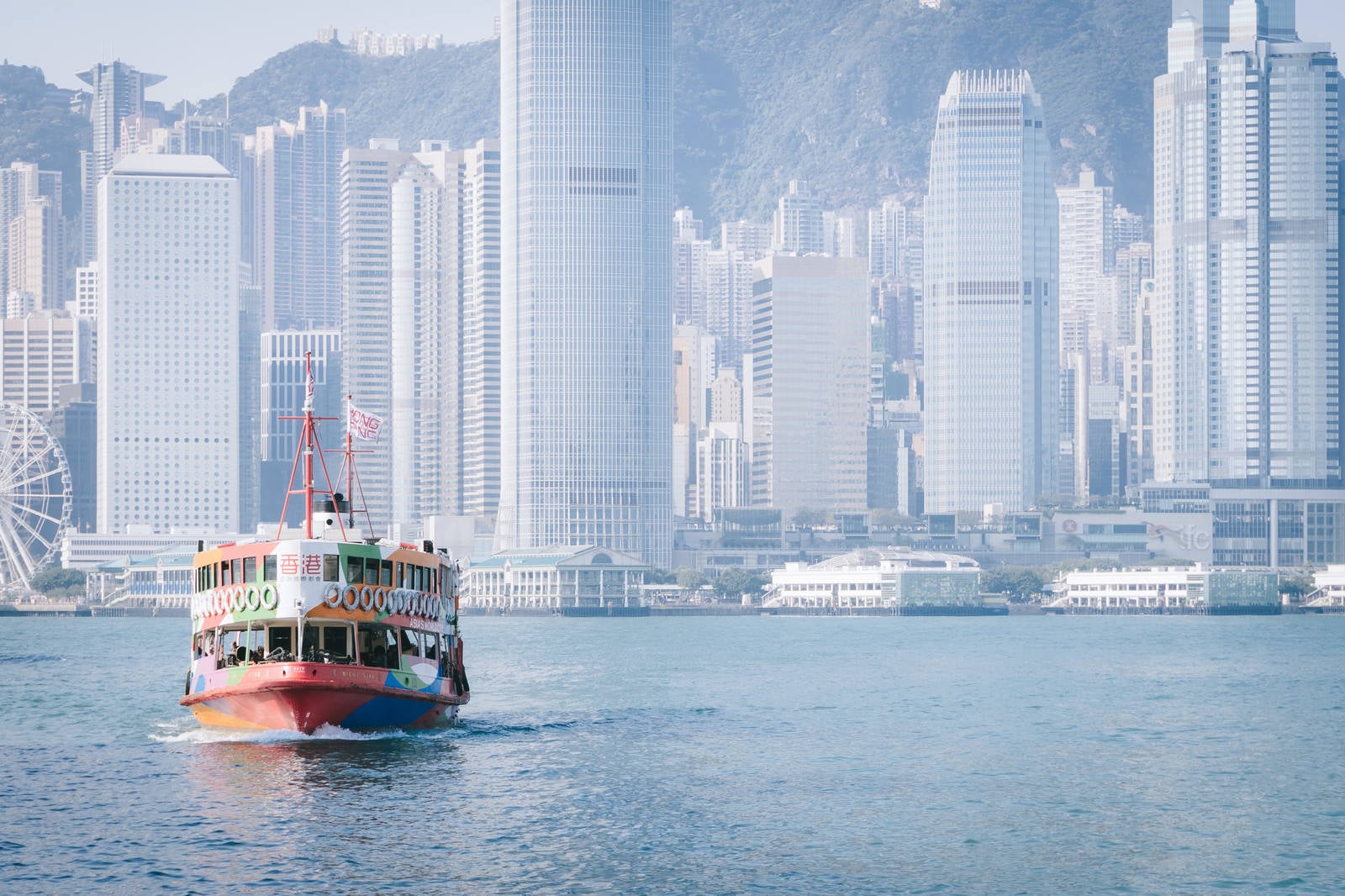 「香港のビル群と観光フェリー」の写真