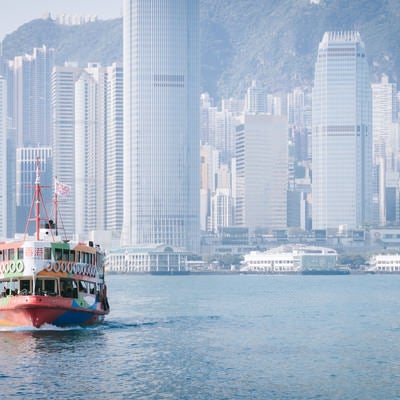 香港のビル群と観光フェリーの写真