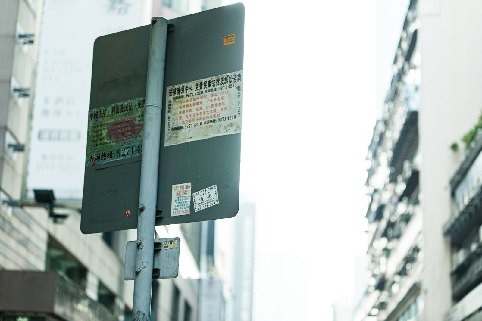 「標識の看板裏まで広告が貼り付けられている（香港）」の写真