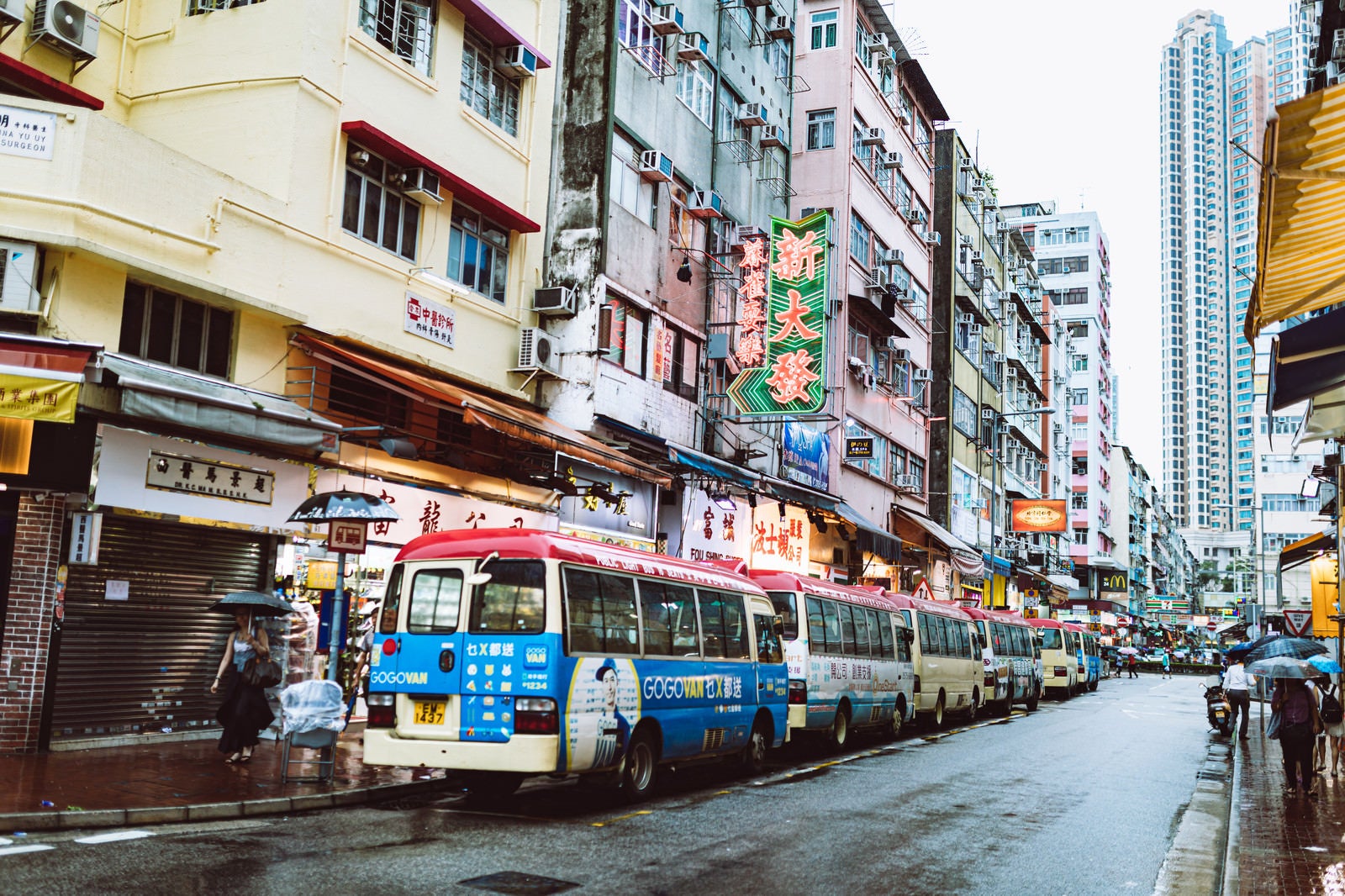 「路駐するバスと雑多な街並み（香港）」の写真