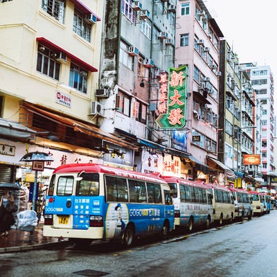 路駐するバスと雑多な街並み（香港）の写真