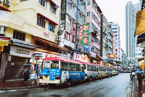 路駐するバスと雑多な街並み（香港）の写真