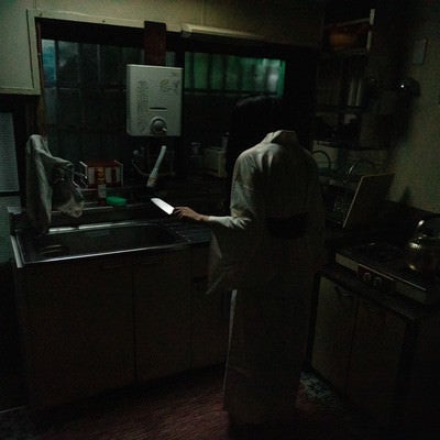 包丁を片手に立ちすくむキッチンの幽霊の写真