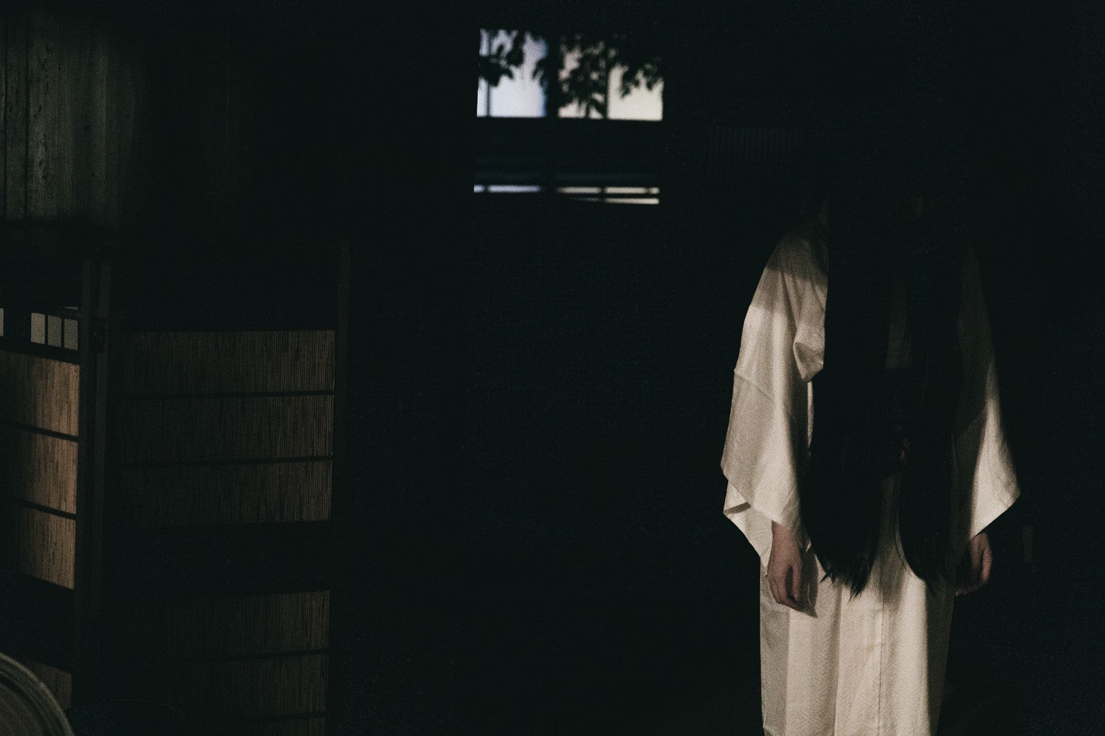 「暗闇の中から下を向いた女性の霊」の写真［モデル：緋真煉］