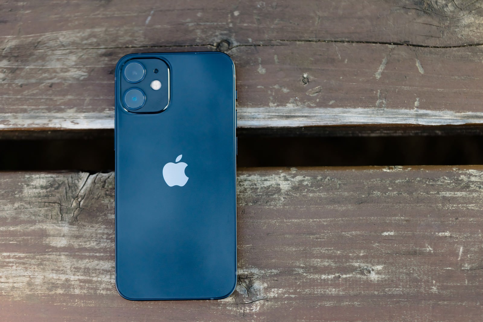 「ベンチに置かれた iPhone 12 mini（ブルー）」の写真