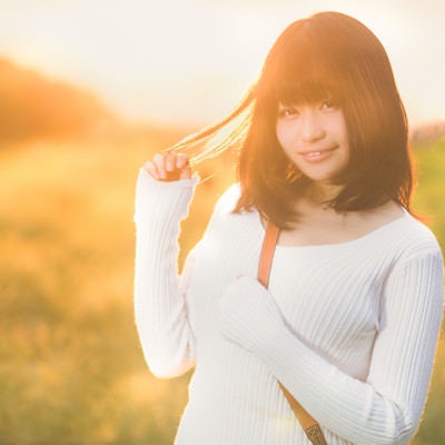 オレンジ色の夕焼けに包まれるむちむちな美女の写真