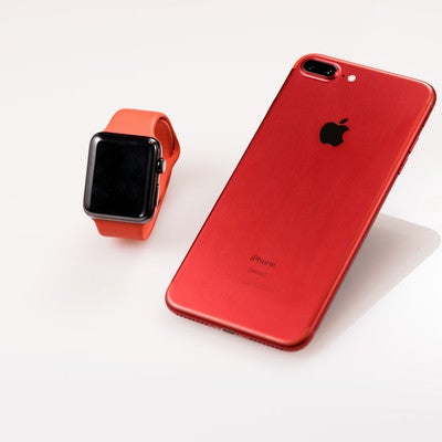 赤いスマートフォンとスマートウォッチの写真