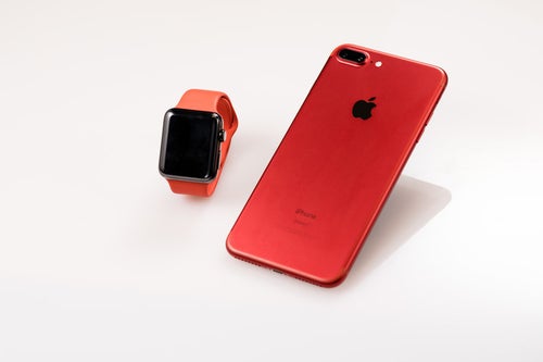赤いスマートフォンとスマートウォッチの写真
