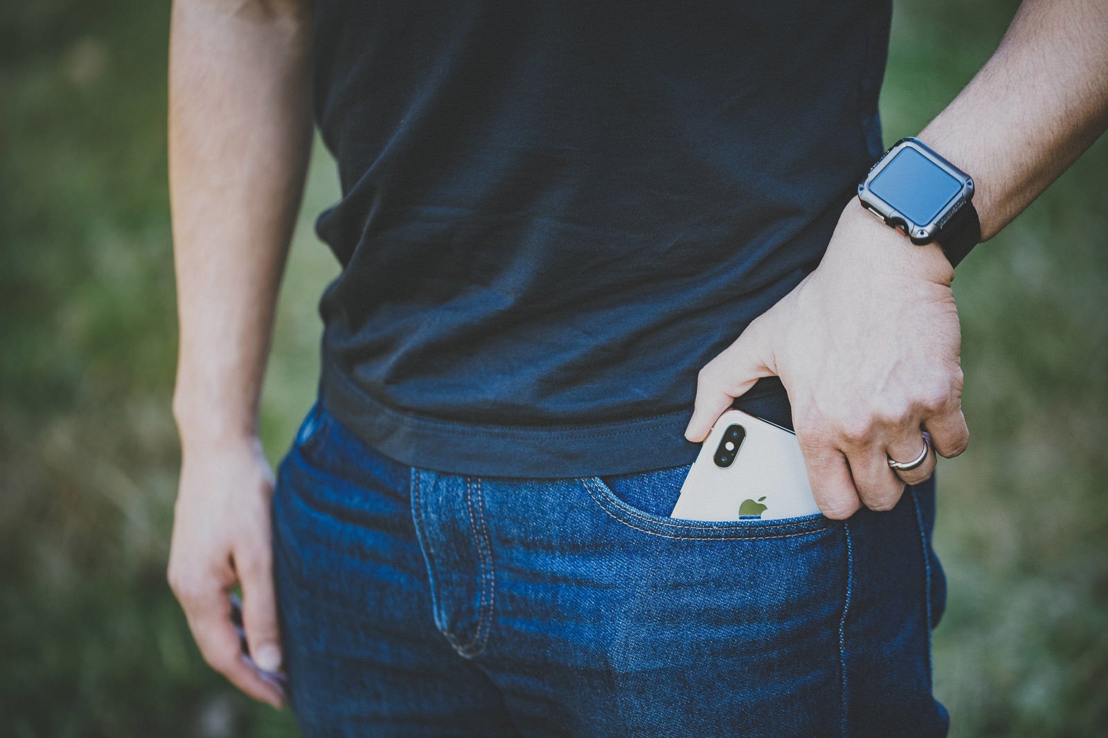 「iPhone X をジーンズのポケットから取り出すシーン」の写真