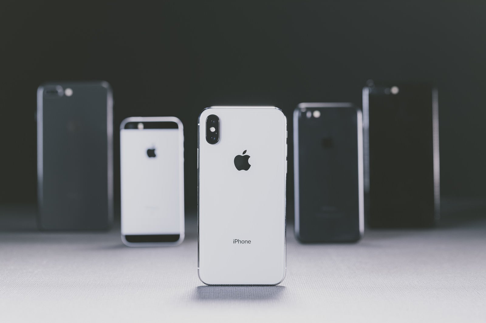 「iPhone X と並べられた別モデルの iPhone」の写真