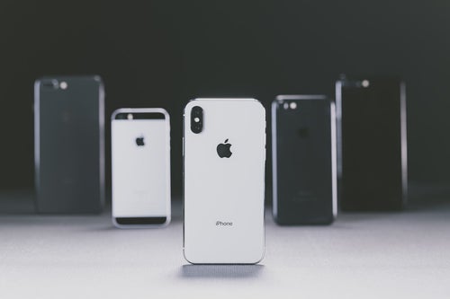 iPhone X と並べられた別モデルの iPhoneの写真