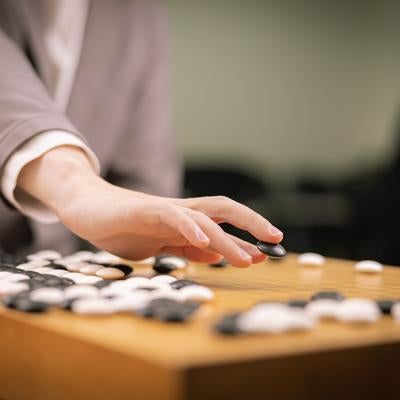 黒石を打つプロ棋士の手元の写真