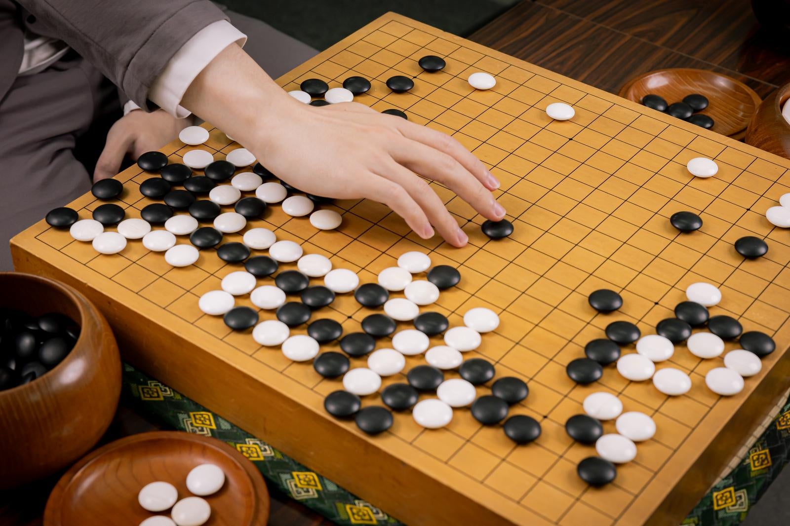 「耳赤の一手を再現するプロ棋士の手元と盤面」の写真