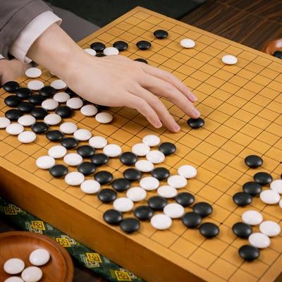 耳赤の一手を再現するプロ棋士の手元と盤面の写真