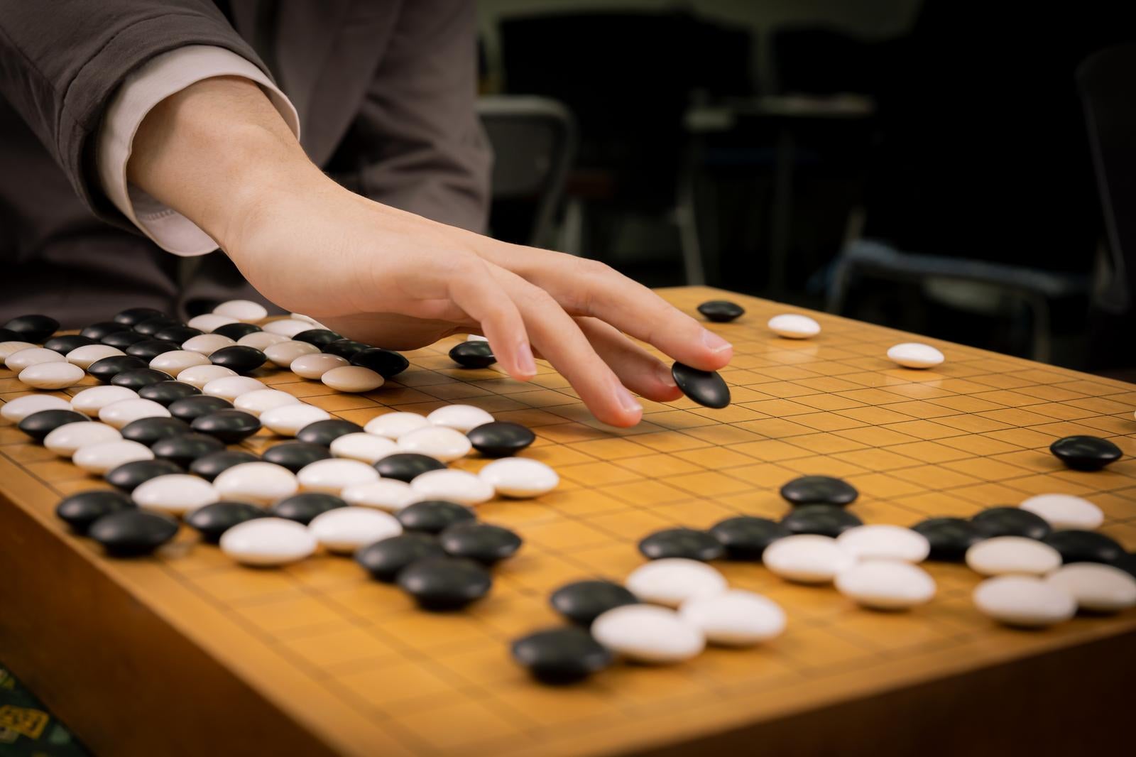 「名局・耳赤の一手を再現するプロ棋士の手元と盤面」の写真