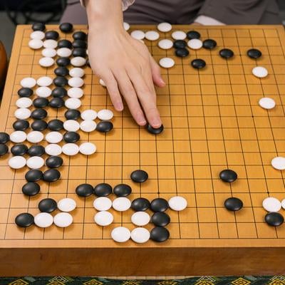 プロ棋士が打つ耳赤の一手と盤面全景の写真