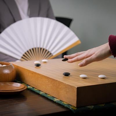 扇子を手にした囲碁棋士の対局風景の写真