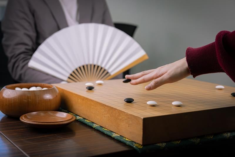 扇子を手にした囲碁棋士の対局風景の写真