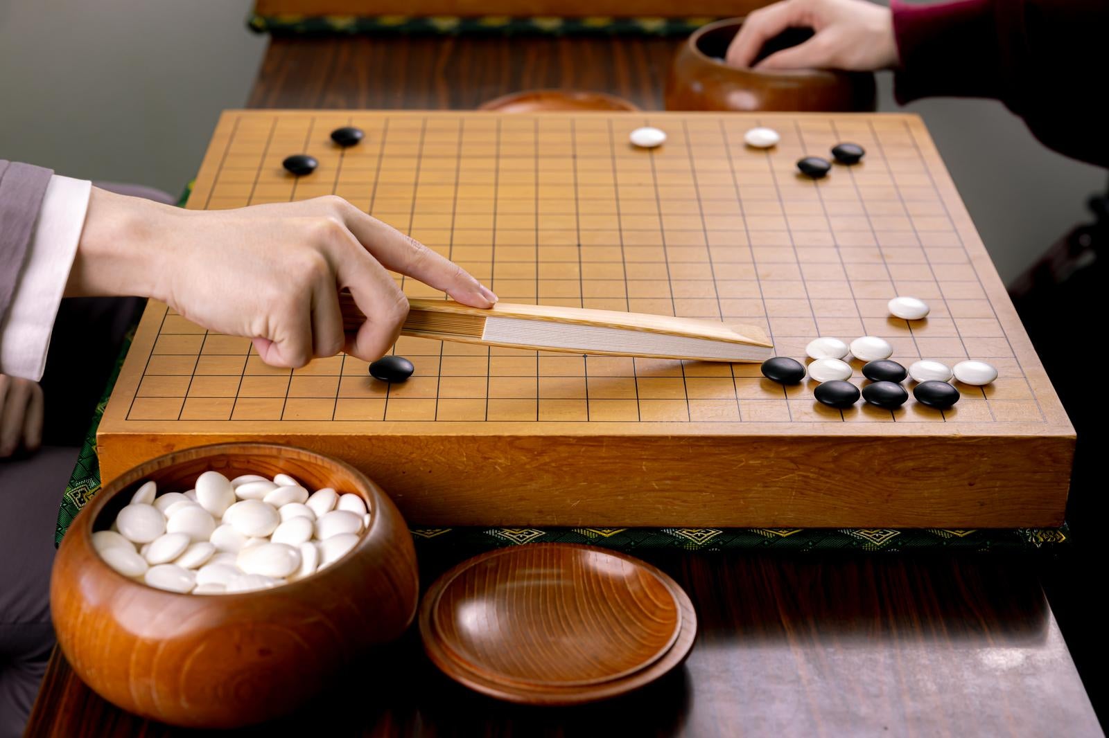 「扇子を使って盤面を解説するプロ棋士」の写真