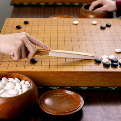 扇子を使って盤面を解説するプロ棋士の写真