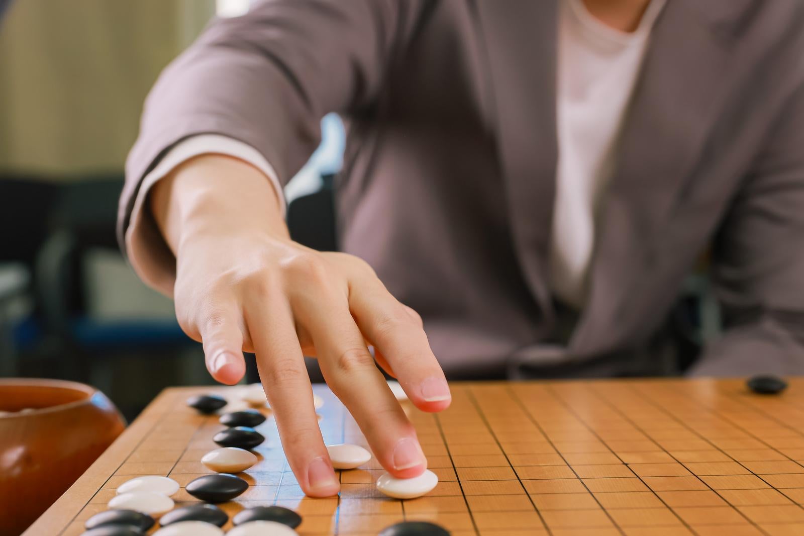 「打ち下ろしの直後（プロ棋士が白石を打つ瞬間）」の写真