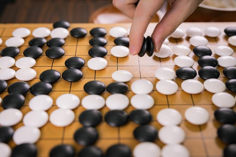 プロ棋士が複数個の石を一気に取るの写真