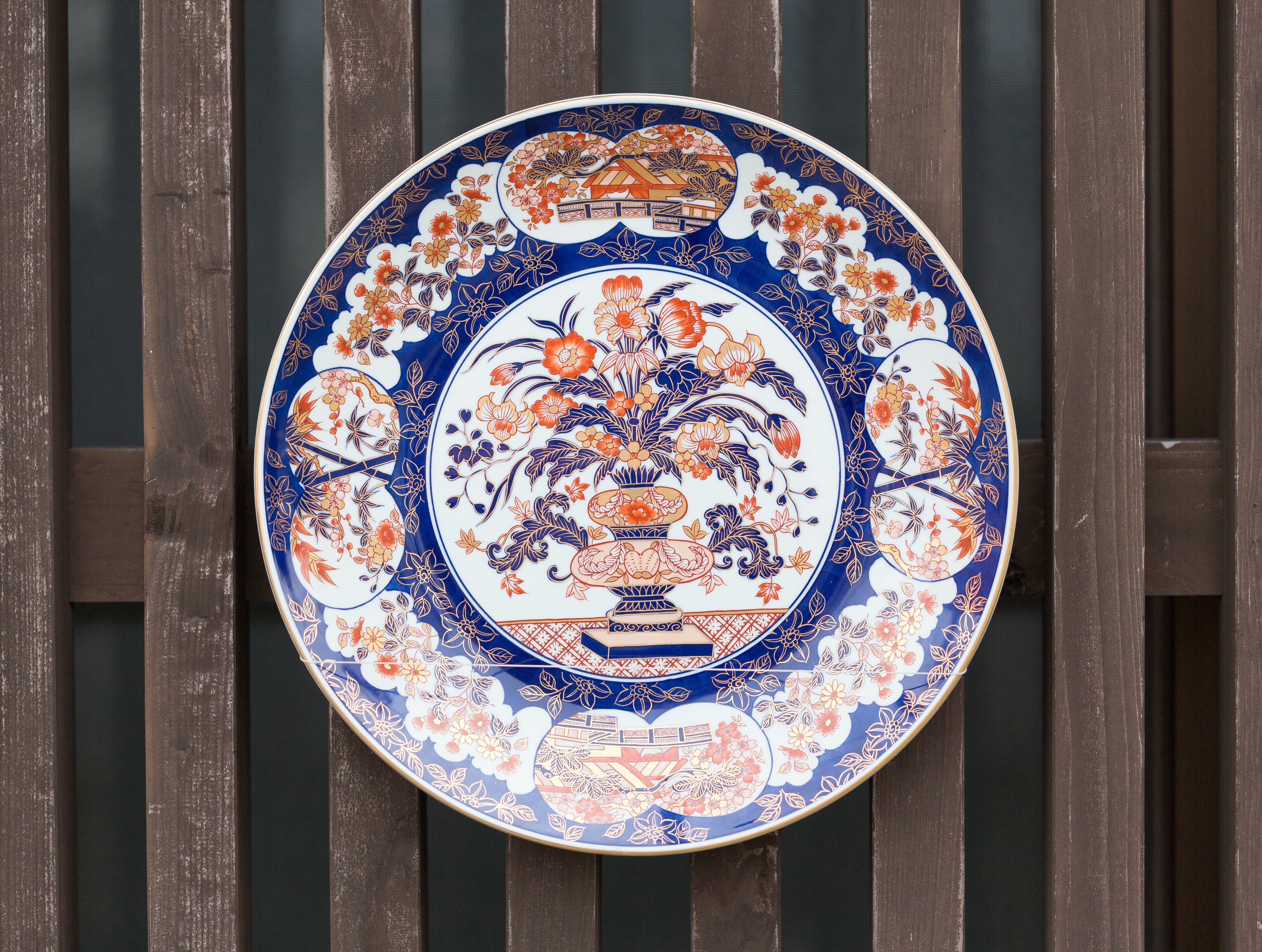 木塀に掛けた伊万里焼の装飾皿、青白の鳳凰文様 - ぱくたそ