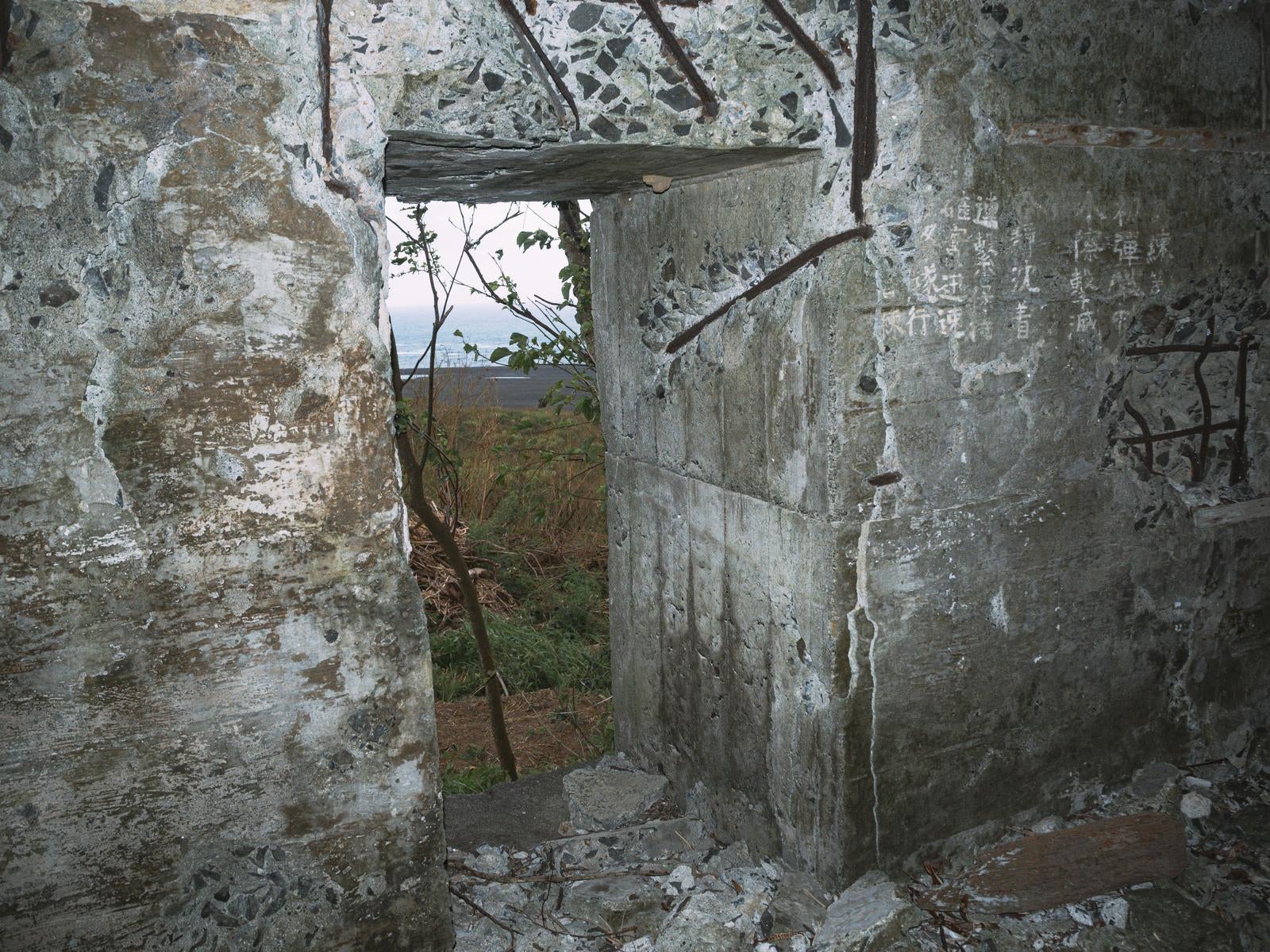 「砲台内部の文字の残された壁の隙間から見える景色」の写真