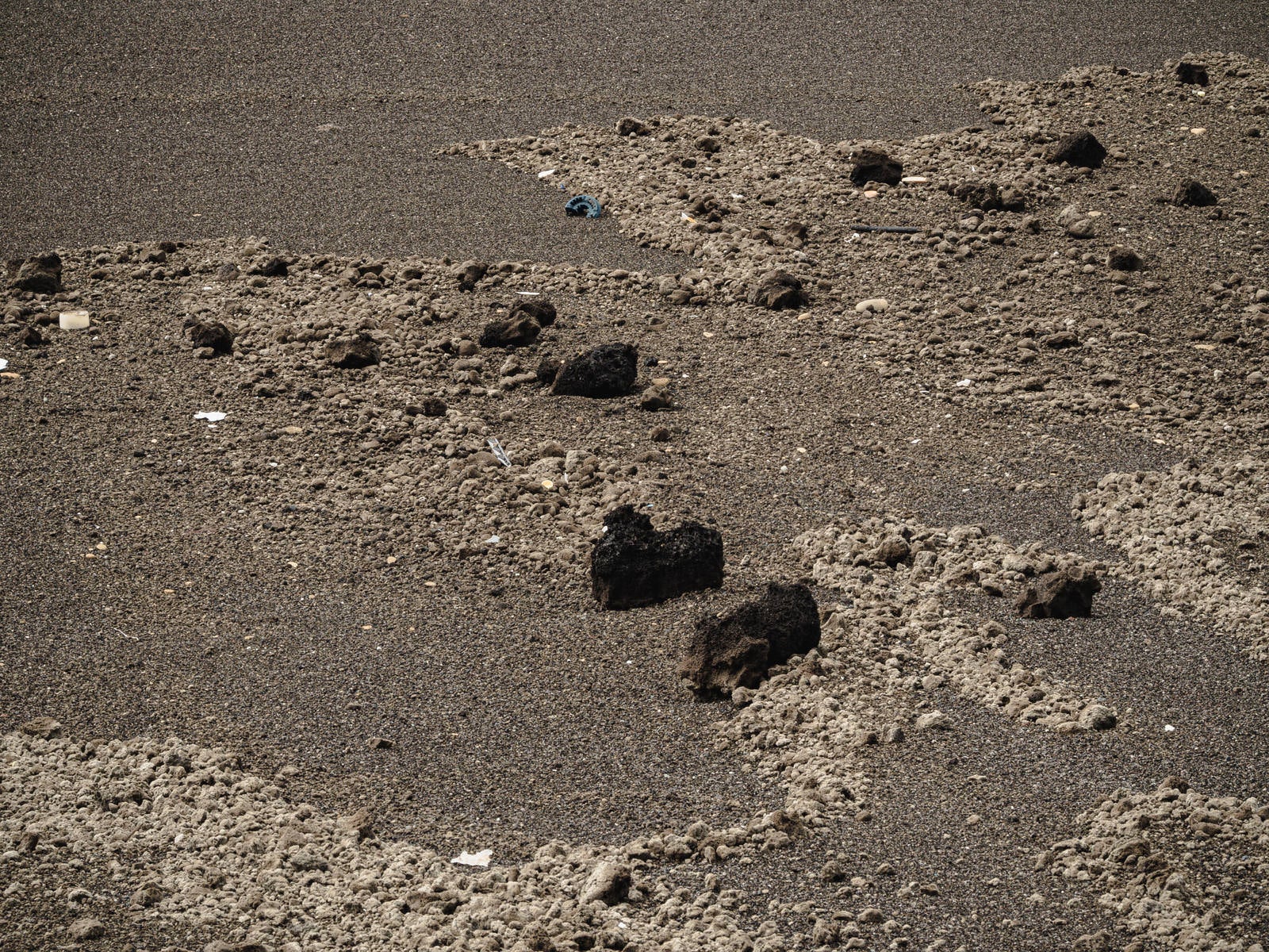 硫黄島・翁浜の黒い砂浜に散らばる軽石と火山岩塊を上から見下ろした写真